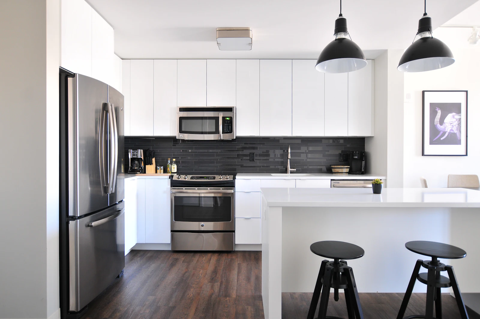 A bright kitchen with pendant lighting over an island. Illustrative photography.